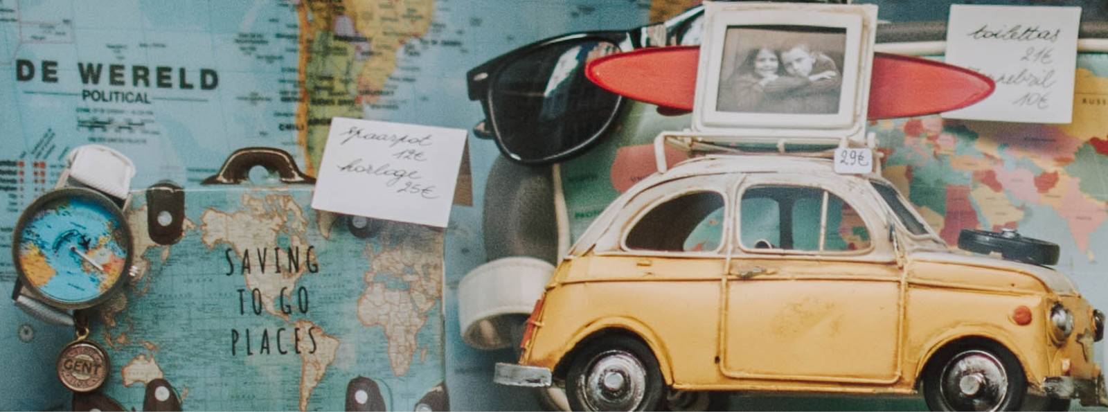 Volkswagon model car in front of a map with a compass and sunglasses